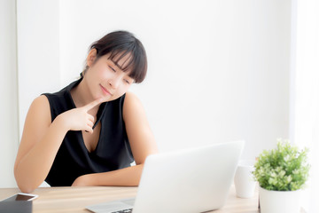 Wall Mural - Beautiful freelance young asian woman thinking and idea working laptop computer at office, writer asia girl thoughtful inspiration writing blogging with notebook in job, business concept.