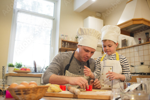 Fotomural Dad and son in chef's hats are cooking