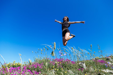 Beautiful, young girl jumps on the slope of a ridge.  Late spring (early summer) Gelendzhik.