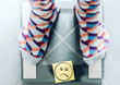 close-up of person in socks on bathroom scale with unhappy smiley face, overweight concept