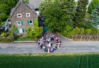 Wedding guests lined up in the shape of heart with bride and groom marriage people