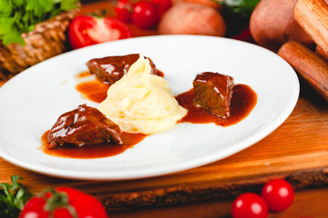 Wall Mural - Fried meat pieces served with mashed potato garnish on white plate.