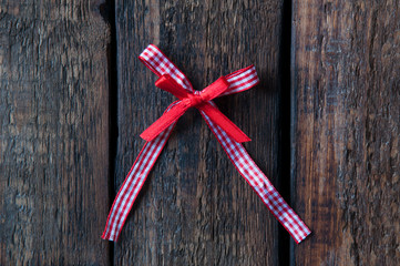 Wall Mural - Red bow on a wooden background. Jewelry