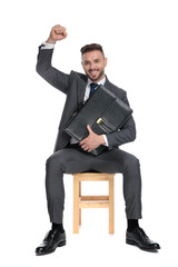 Wall Mural - happy young businessman celebrating victory and holding suitcase