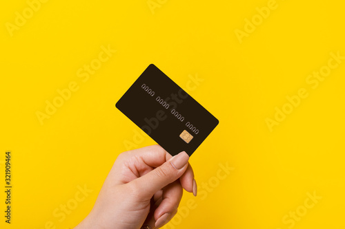 Cuadros en Lienzo Female hand holding credit card on yellow background