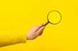 magnifier in hand  over yellow background