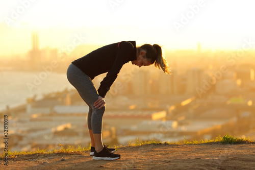 Cuadros en Lienzo Exhausted runner resting after running in city outskirts