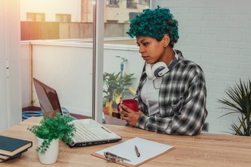 young girl or student with laptop at home or in the office with cup of coffee