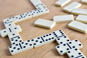 Playing dominoes on a wooden table. Dominoes game concept.