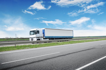 Sticker - A big truck and trailer on the countryside road against a blue sky with clouds