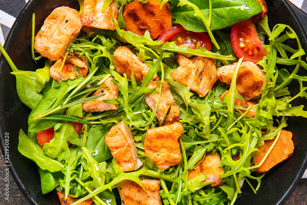 Plate with tasty salmon salad, closeup
