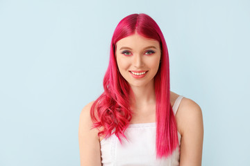 Beautiful young woman with unusual hair on color background