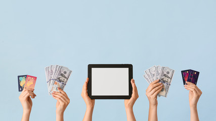 Wall Mural - Female hands with money, credit cards and tablet computer on color background. Concept of online banking