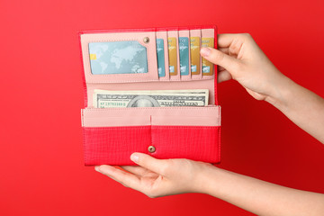 Poster - Female hands with wallet, credit cards and money on color background