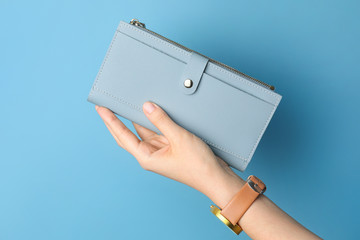 Female hand with wallet on color background