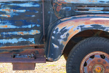 A Rusted Blue Truck Door Panel And Wheel