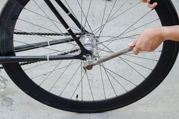 Tighten the bolts with a wrench to change the bicycle wheel.