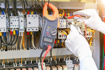 Electrician measuring voltage in distribution board, closeup