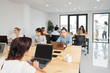 © DragonImages - Open space office of IT company with many software developers working on one big project