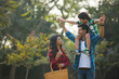© IndiaPix - Happy young couple standing in a garden with the man carrying their son on his shoulders and the woman carrying a basket.
