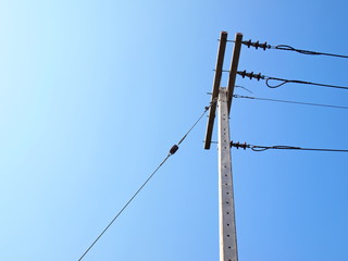 Guy Wire and high voltage cable on the pole It is a cable for fixing the tension of the post and the electrical cable to adjust the balance in the last column. On the blue sky background