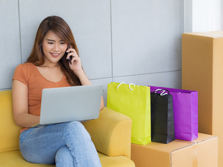 Wall Mural - Beautiful Asian businesswoman in a brown casual talking on a smartphone