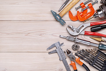 Set of various home tools lying in  row on  light wooden background. Men's style. Studio shot. Copy space.