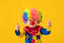 Funny Kid Clown Playing Against Yellow Background