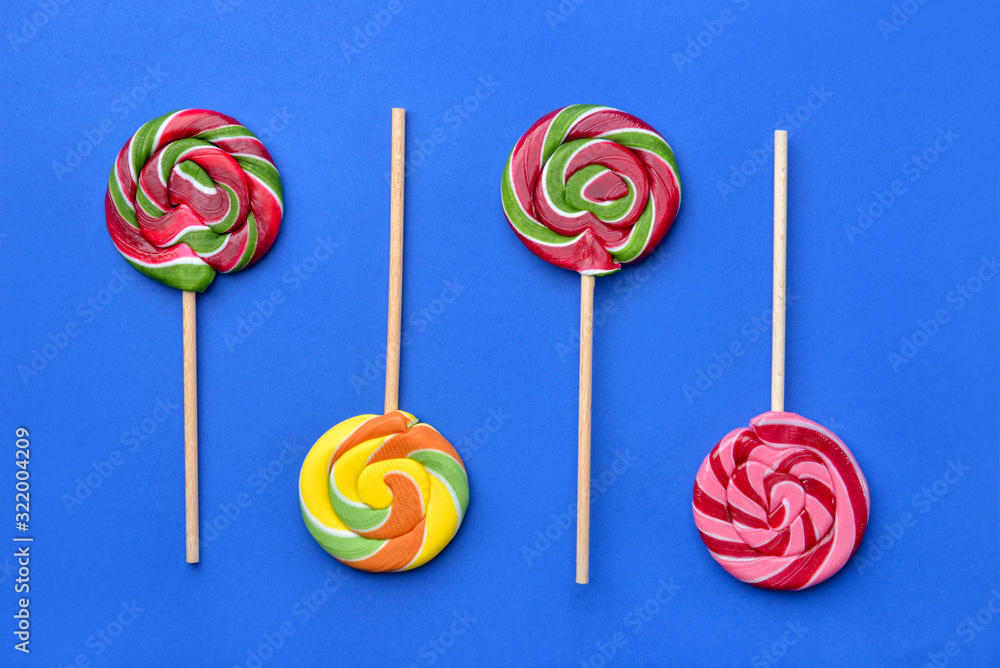 Tasty lollipops on color background
