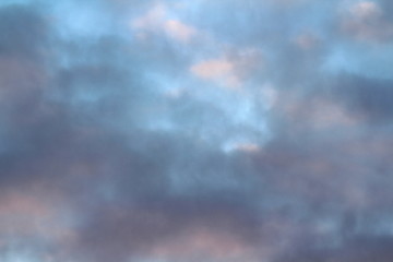 Wall Mural - dramatic blue sky with clouds backlit by the sun at dusk.