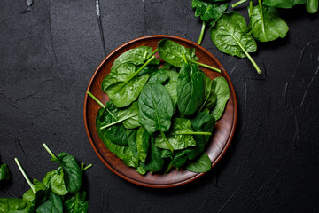 fresh spinach leaves on dark backgrownd. Top view