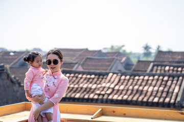 Canvas Print - Young mum walking on street at Hoi An Ancient town with her daughter.