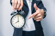 business people hand finger pointing at clock times at 8 o'clock, reminder time to do something or timing notice concept