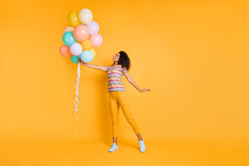 Poster - Full length body size view of nice lovely dreamy cheerful cheery wavy-haired girl in striped t-shirt holding air ball enjoying festive isolated on bright vivid shine vibrant yellow color background