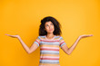 © deagreez - Portrait of her she nice attractive doubtful wavy-haired girl in striped tshirt holding on palms invisible objects weighing thinking isolated on bright vivid shine vibrant yellow color background
