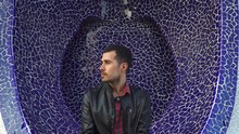 Serious Young Man With Beard, Black Hairs, Looks At Camera Then Turn Head. Purple Background. Model With Casual Checkered Shirt And Leather Jacket
