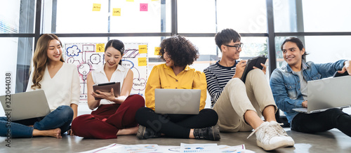Fotomural Group of young happy Asian creative business people or hipster student using electronic devices tablet and laptop connection together in modern office