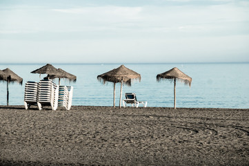 Canvas Print - Beach loungers and parasol on the beach