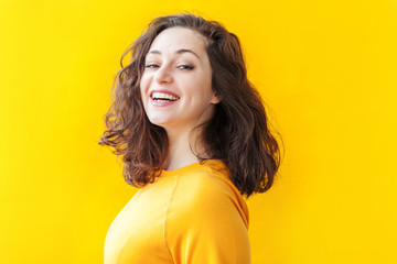 Happy girl smiling. Beauty portrait young happy positive laughing brunette woman on yellow background isolated. European woman. Positive human emotion facial expression body language