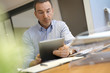 © goodluz - Man in office using digital tablet