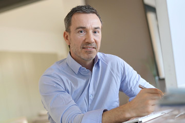 Wall Mural - Portrait of businessman in office looking at camera