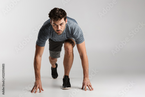 Fotomural Confident young sportsman standing ready to start running