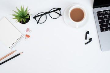 Wall Mural - Work space office business and education concept on white table desk background with laptop computer and coffee cup, green plant and glasses, coffee cup and earphone,Top view with copy space, flat lay