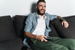 © Drobot Dean - Attractive young bearded man relaxing on a couch at home
