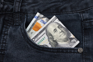 One hundred dollar banknote money in pocket jeans pants background texture. 100 dollar bill close up