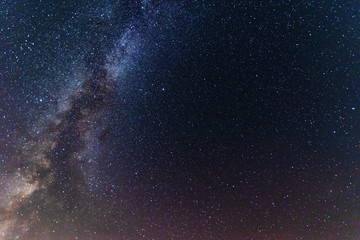 Wall Mural - a night on the lake with a bright milky way in the sky and millions of stars glittering in the water