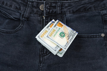 One hundred dollar banknote money in pocket jeans pants background texture. 100 dollar bill close up