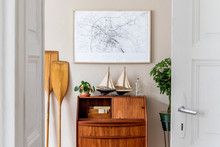 Stylish And Vintage Interior Design Of Living Room With Wooden Retro Commode,  Plants, Ships, Paddle, Map And Elegant Personal Accessories. Mock Up Poster Frame On The Wall. Template. Home Decor.