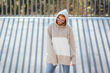 Wall Mural - Outdoor photo of pretty, young model girl dressed in gray hoodie