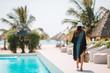 © travnikovstudio - Woman relaxing by the pool in a luxury hotel resort enjoying perfect beach holiday vacation